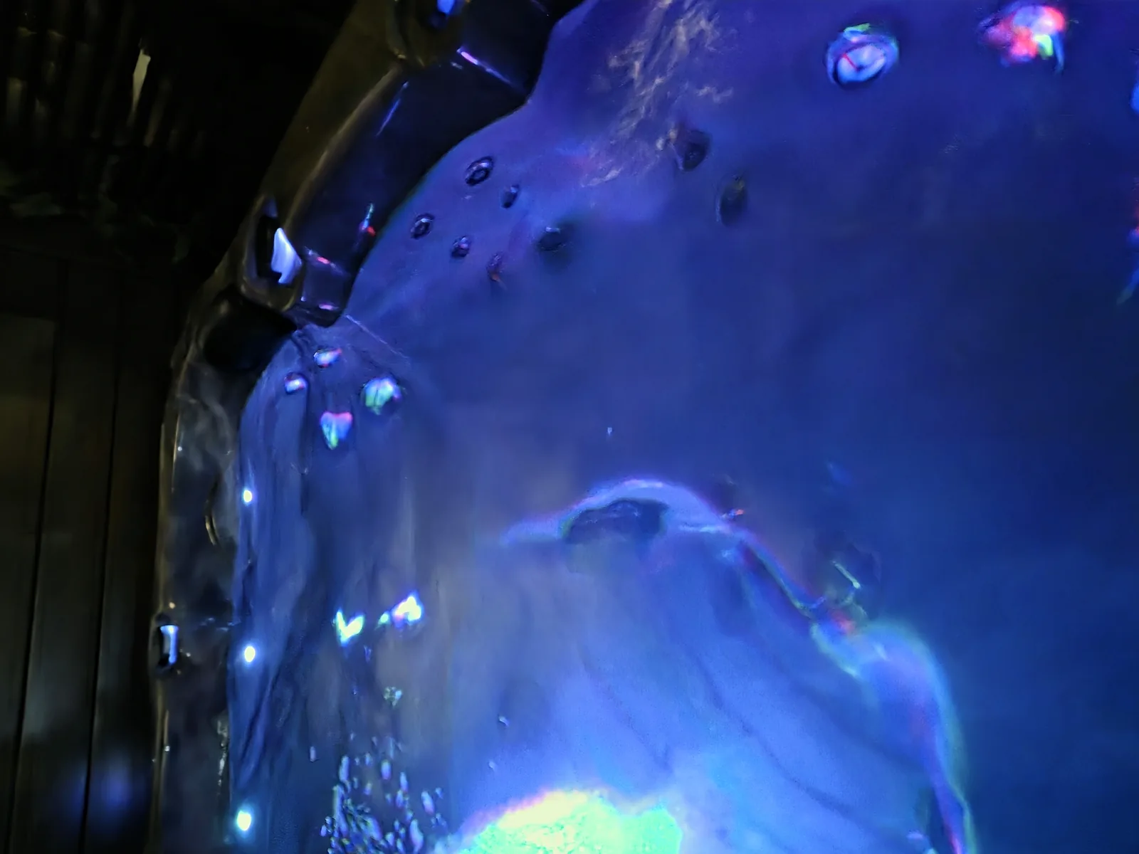 Bassin d’un spa vu de dessus la nuit, eau éclairée en bleu par les LED.
